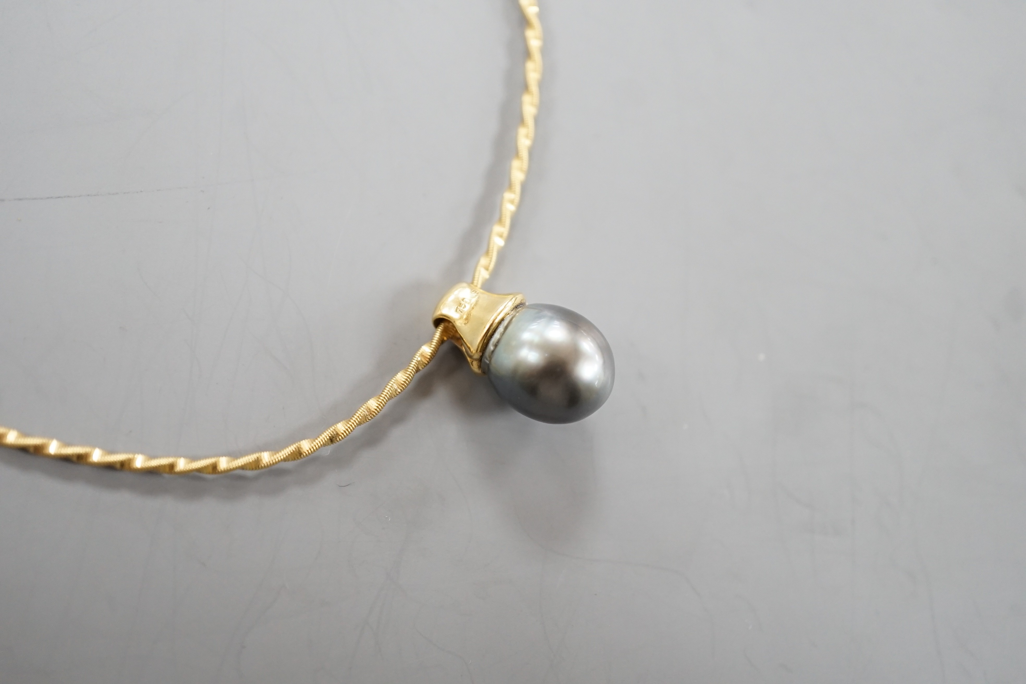 A modern 18k, cultured Tahitian pear and diamond chip set pendant, 19mm, on a 750 yellow metal necklet, approx. 36cm, gross weight 10.3 grams.